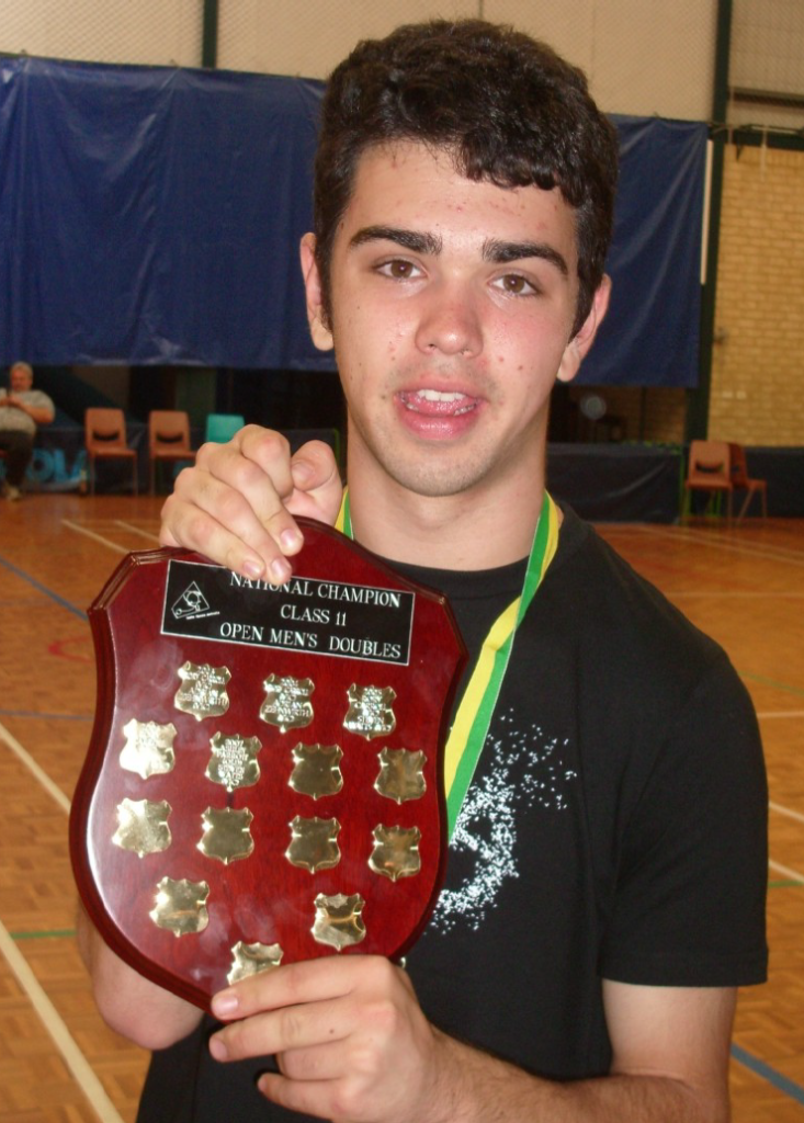 Steven holding up the shield for the National Table Tennis Championships, Class Two, Open Men's Doubles.
