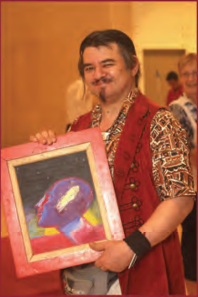 Stanley smiles while holding his framed painting
