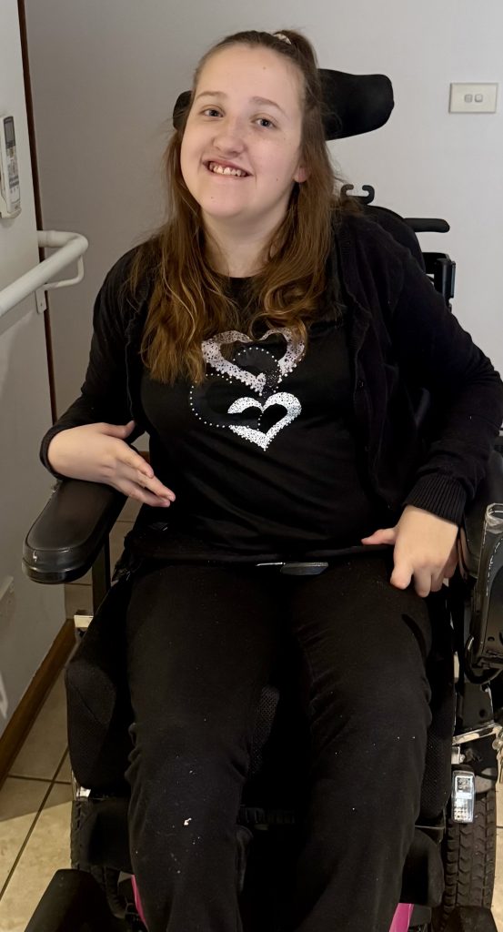 Chloe smiling as she sits in her wheelchair